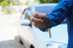 The car owner is standing the car keys to the buyer. Used car sales photo