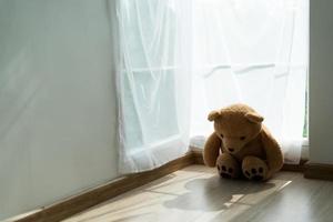 The brown teddy bear was sadly and disappointment. The teddy bear  feeling lonely. Child concept of sorrow. photo