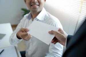 Businessmen receive salary or bonuses from management or Boss. Company give rewards to encourage work. Smiling businessman enjoying a reward at the desk in the office. photo