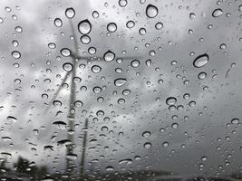 Rain on the car glass Outside is a windmill view. Sad and lonely background photo