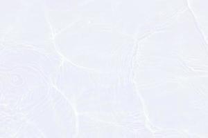 Defocus blurred transparent white colored clear calm water surface texture with splashes and bubbles. Trendy abstract nature background. Water waves in sunlight with copy space. White water shine photo