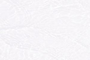 Defocus blurred transparent white colored clear calm water surface texture with splashes and bubbles. Trendy abstract nature background. Water waves in sunlight with copy space. White water shine photo