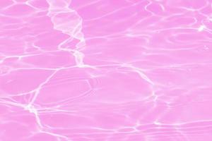 Defocus blurred transparent pink colored clear calm water surface texture with splashes and bubbles. Trendy abstract nature background. Water waves in sunlight with copy space. Pink water shining. photo