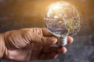 bombilla de luz mundial en la mano, hombre sosteniendo la tierra azul, salvar los conceptos de la tierra. elementos de esta imagen proporcionados por la nasa foto