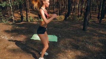 slender sport girl in short shorts with round buttocks jumping on nature close up in slow motion video