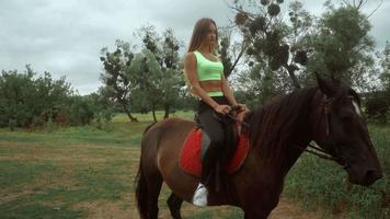 cutie young girl rides on horseback at daytime