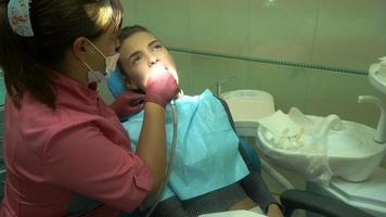 süßes junges Mädchen behandelt ihre Zähne von einem Zahnarzt