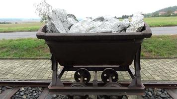 Old mining trolley minecart loaded with stones stands on rails video