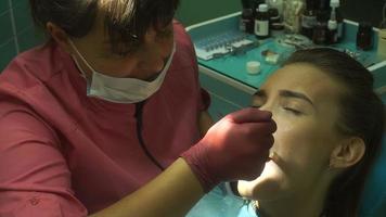 El primer plano de una joven trata los dientes del dentista video