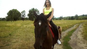 young girl riding astride beautiful Brown horse outside video