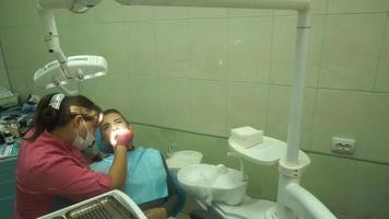 junges schönes mädchen behandelt ihre zähne von einem zahnarzt