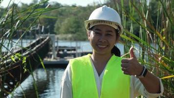 Portrait of environmental engineer wearing white helmet working at reservoir. Water and ecology concept. video