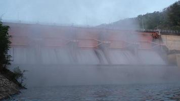 cenário da manhã na represa de kiew lom, lampang, tailândia. barragem hidrelétrica, comporta com água fluindo pelo portão. barragem com central hidroeléctrica e rega. video