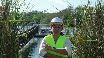 retrato de ingeniero ambiental con casco blanco trabajando en el embalse. concepto de agua y ecología. video