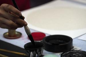 japanese woman writing ideograms with brush photo