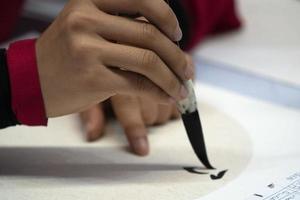 japanese woman writing ideograms with brush photo