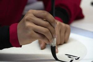 mujer japonesa escribiendo ideogramas con pincel foto