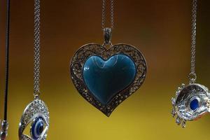 Turquoise Heart pendant isolated on yellow photo