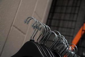 many coat hangers in storage room hook close up photo