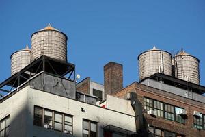 tanques de agua en el techo de los edificios rascacielos de manhattan de nueva york foto