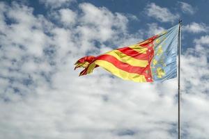 ondeando la bandera de valencia españa en el cielo azul foto