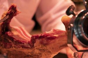 Hands while cutting spanish ham photo