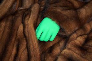 mano verde en el detalle de la ropa de piel animal foto