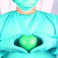 Surgeon holding a green hearth photo