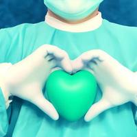 Surgeon holding a green hearth photo