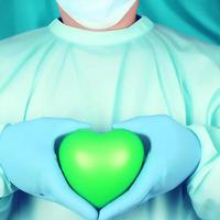 Surgeon holding a green hearth photo