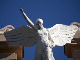 victory fascism angel statue on the top of old building photo