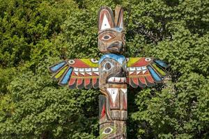 Totem wood pole on forest  background photo