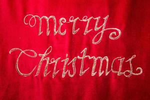 merry christmas embroidery on red fabric photo