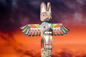 Totem wood pole in the gold cloudy background photo