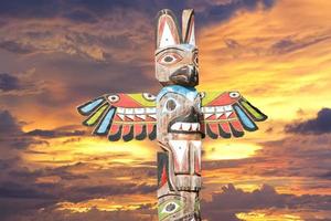 Totem wood pole in the gold cloudy background photo