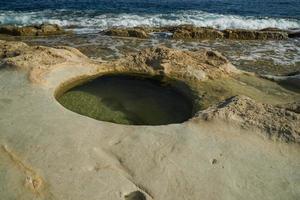 saint peter pools Malta rock formation hole on rocks photo