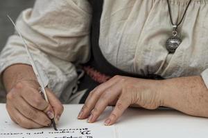 hands writing a letter with a plume photo