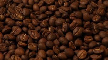 Zeitlupe von fallenden gerösteten Kaffeebohnen. Bio-Kaffeesamen.