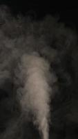långsam rörelse vertikal video av vit rök, dimma, dimma, ånga på en svart bakgrund.