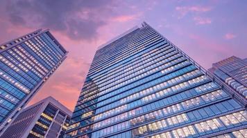 vista de lapso de tiempo del cielo crepuscular mirando hacia el edificio de oficinas moderno. concepto empresarial, corporativo y financiero. video