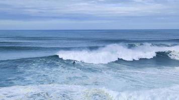 surfer reitet auf einer riesigen großen welle in nazare, portugal. größten wellen der welt. touristisches Ziel für Surfer und Liebhaber radikaler Sportarten. Jetskis im Wasser. Nazare-Schlucht video