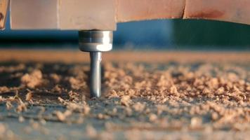 de snijwerk van hout Aan een tafel met een geautomatiseerd snijdend systeem. detailopname van een frezen snijder dat bezuinigingen een patroon Aan hout video