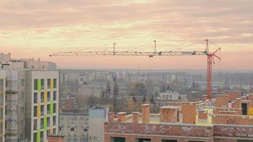 A construction crane is working on a construction site. Construction at sunset. video