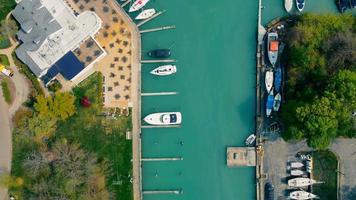 Aerial top view of cake and parked yacht on Lake Michigan. Boats in the port and beautiful green water.