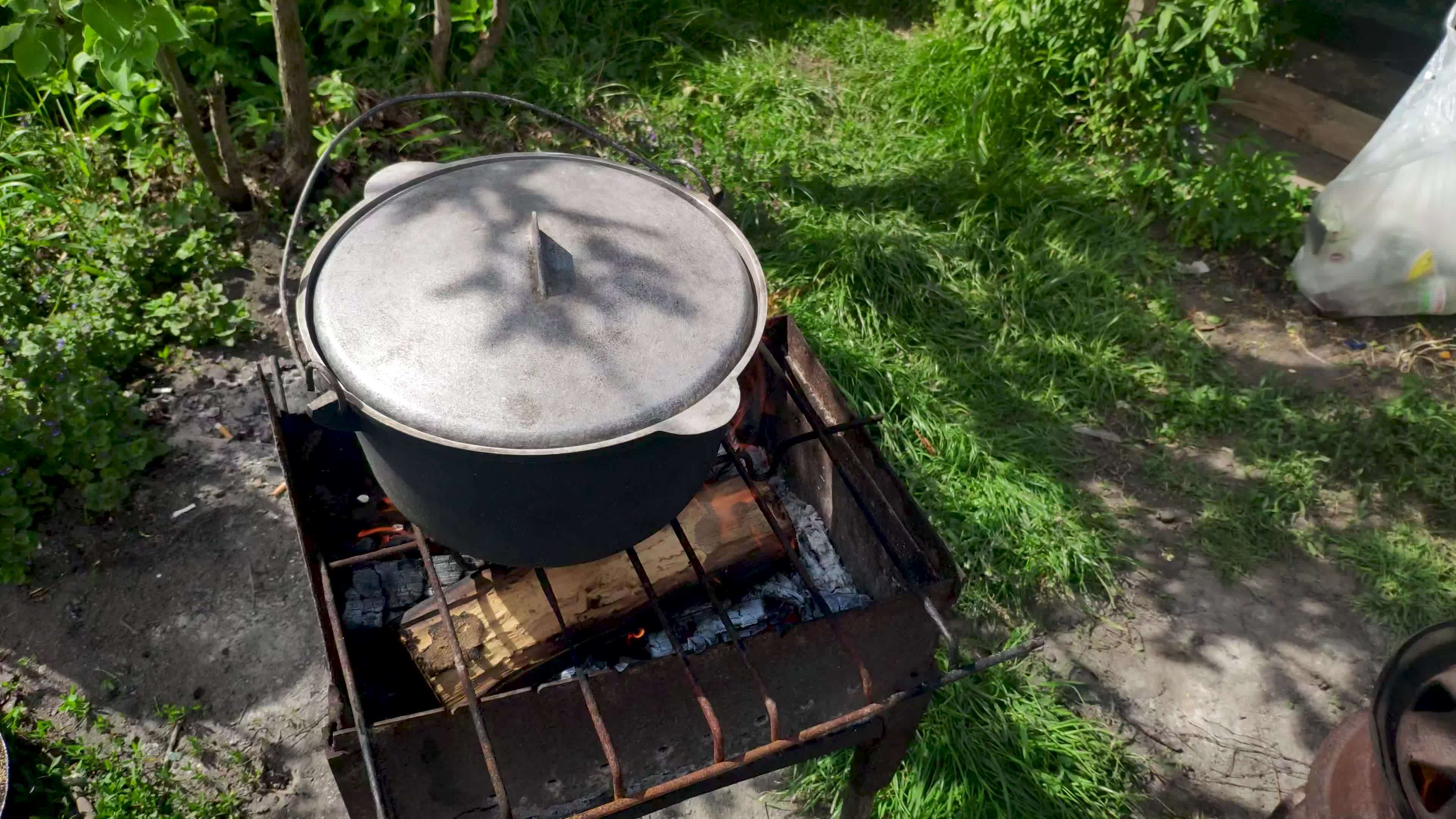 Large cauldron with a lid on a fire. Big vat with food cooking on