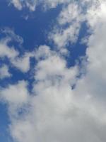 hermosas nubes blancas sobre fondo de cielo azul profundo. imagen elegante del cielo azul a la luz del día. grandes nubes esponjosas suaves y brillantes cubren todo el cielo azul. foto