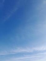 Beautiful white clouds on deep blue sky background. Elegant blue sky picture in daylight. Large bright soft fluffy clouds are cover the entire blue sky. photo
