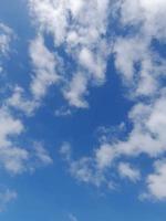 Beautiful white clouds on deep blue sky background. Elegant blue sky picture in daylight. Large bright soft fluffy clouds are cover the entire blue sky. photo