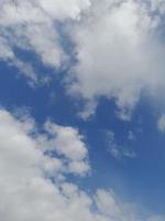 hermosas nubes blancas sobre fondo de cielo azul profundo. imagen elegante del cielo azul a la luz del día. grandes nubes esponjosas suaves y brillantes cubren todo el cielo azul. foto