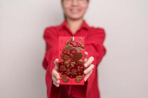 mujer sosteniendo un sobre rojo chino con conejo dorado y palabra de bendición, regalo de dinero para felices vacaciones de año nuevo lunar. frase china significa felicidad, salud, suerte y riqueza foto